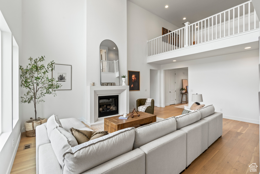 Living room with light hardwood / wood-style flooring and a high ceiling