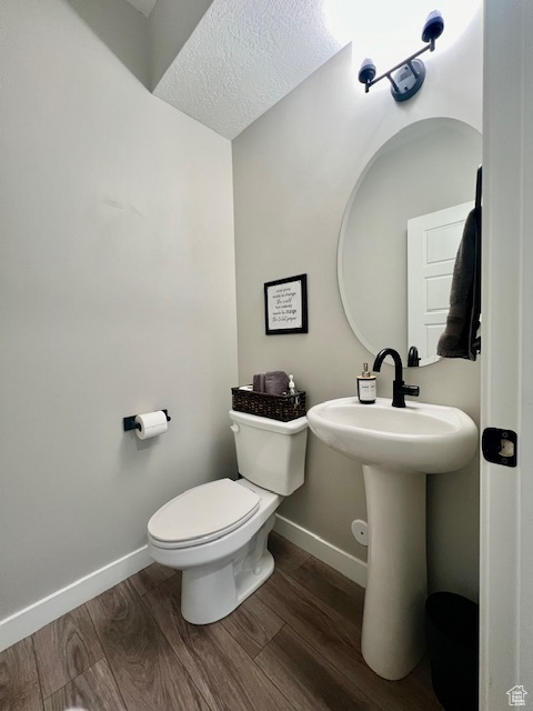 Bathroom featuring a textured ceiling, toilet, and hardwood / wood-style floors