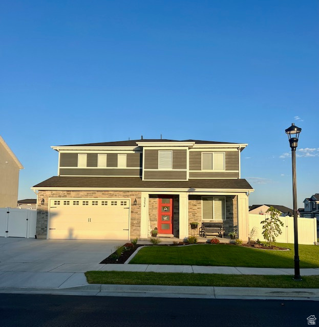 View of front facade featuring a garage and a front yard