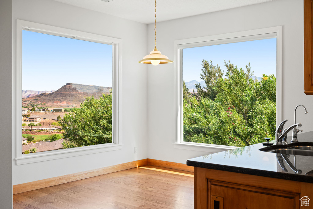 Dining room featuring sink, light wood-type flooring, a mountain view, and plenty of natural light