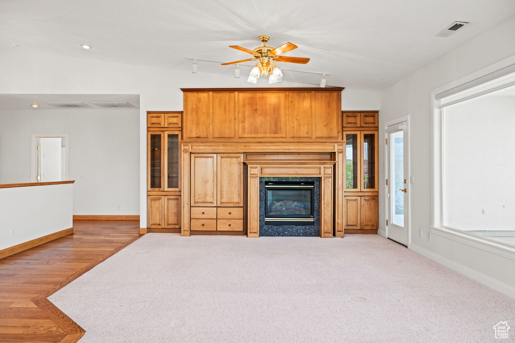 Unfurnished living room featuring ceiling fan, a fireplace, lofted ceiling, and carpet flooring