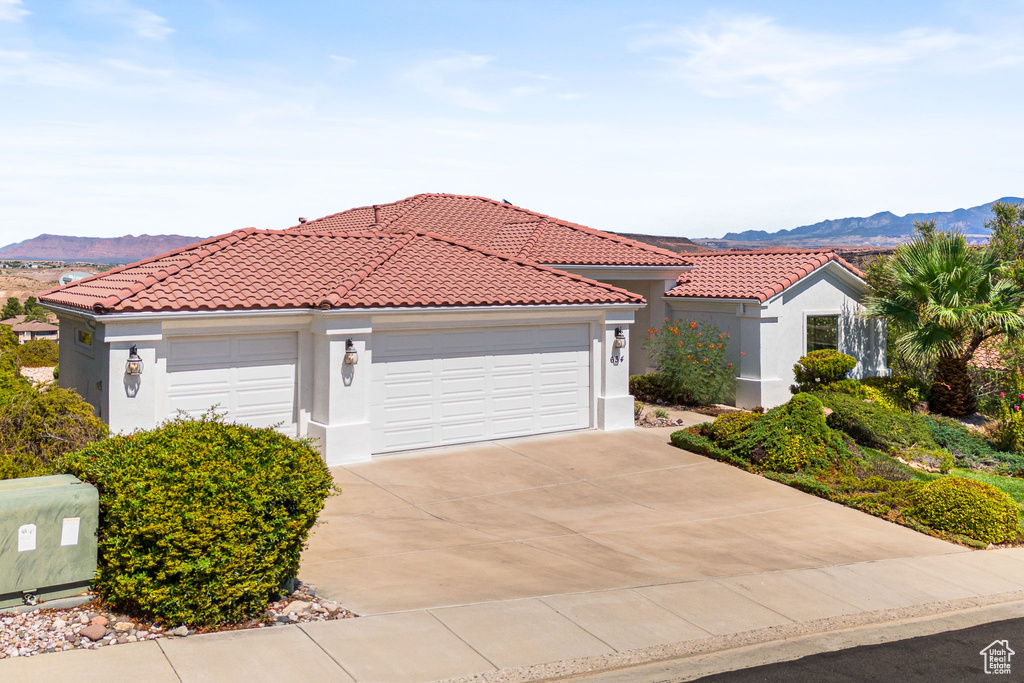 Mediterranean / spanish house featuring a mountain view and a garage