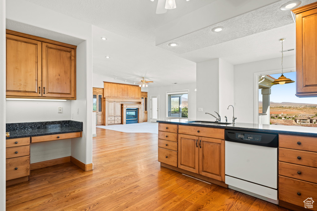 Kitchen featuring hanging light fixtures, white dishwasher, ceiling fan, sink, and light hardwood / wood-style floors