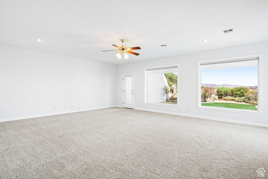 Carpeted empty room with ceiling fan