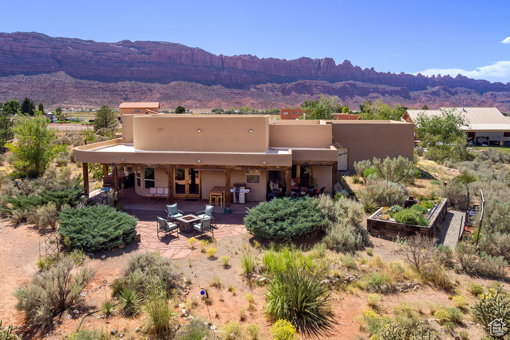 Back of house with a mountain view and a patio area