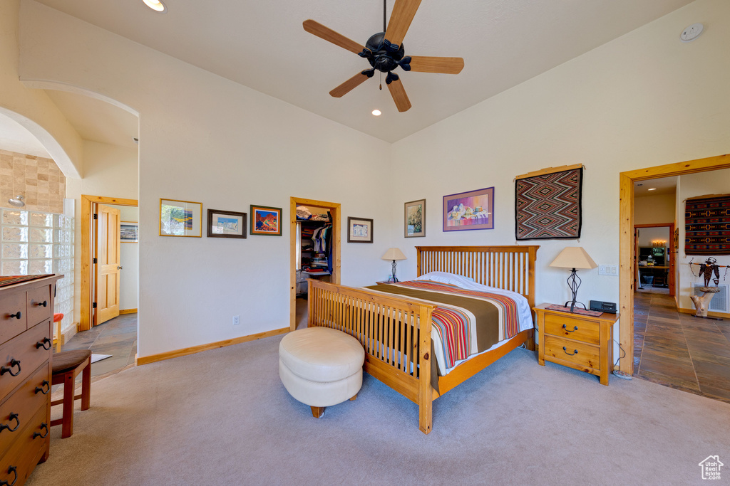 Bedroom featuring a closet, tile patterned floors, a spacious closet, and ceiling fan