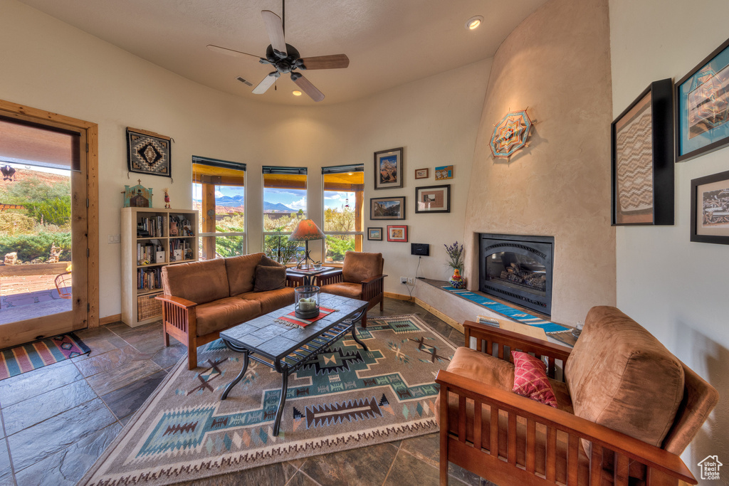 Tiled living room featuring ceiling fan and a fireplace