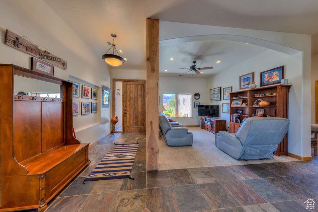 Living room with dark tile patterned flooring and ceiling fan