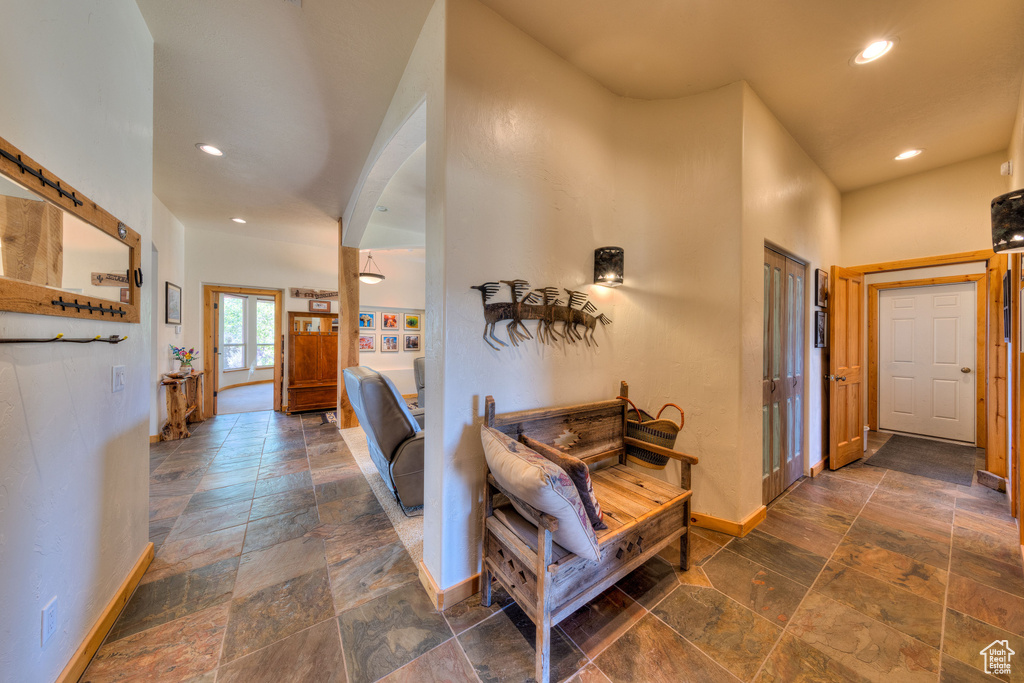 Hallway featuring a high ceiling and dark tile patterned floors