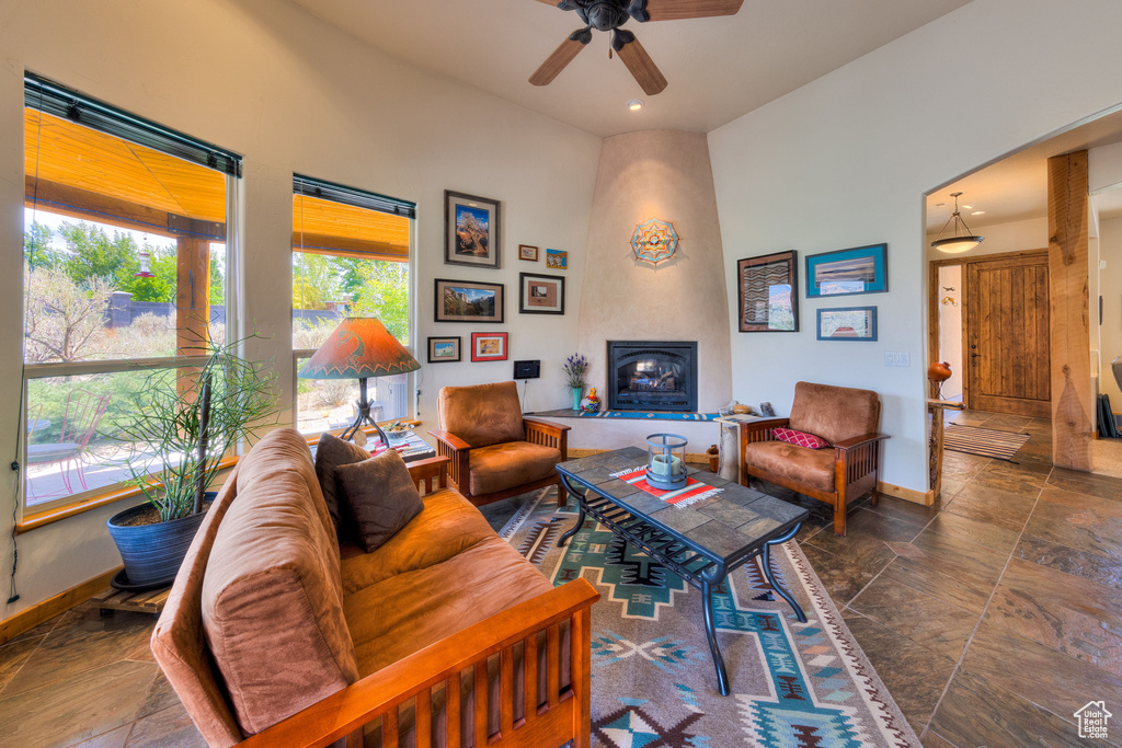 Living room featuring a large fireplace, tile patterned floors, and ceiling fan