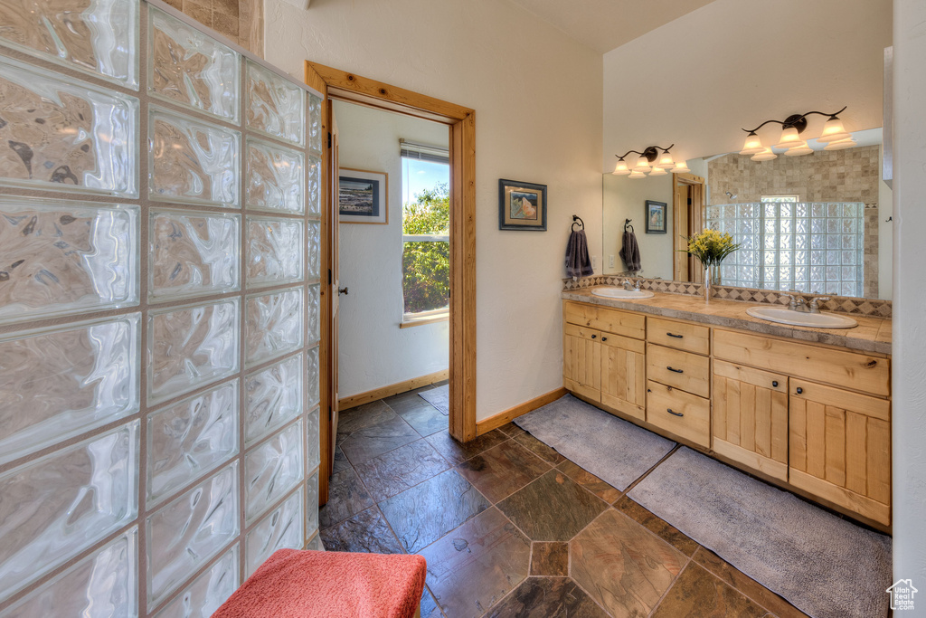 Bathroom featuring dual bowl vanity and tile patterned flooring