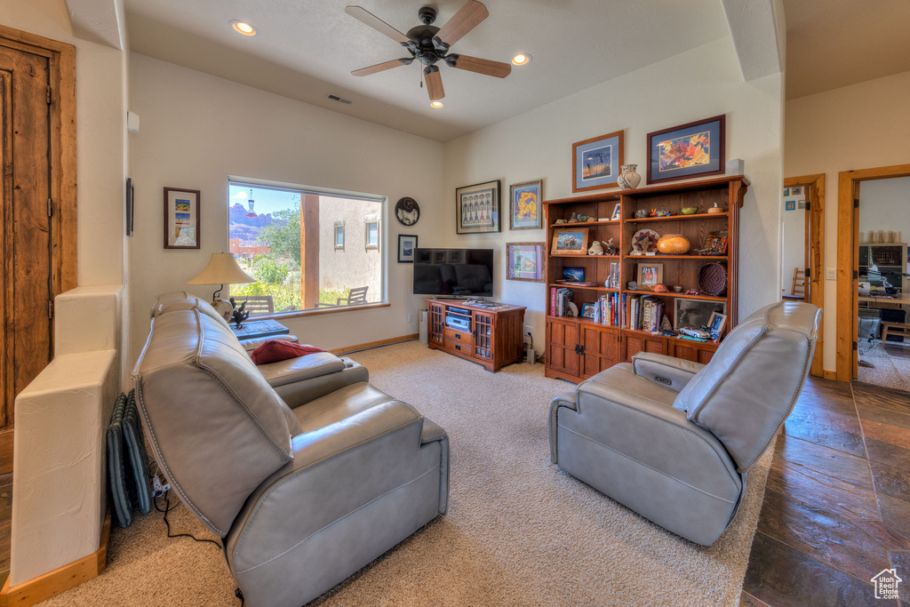 Living room with carpet flooring and ceiling fan