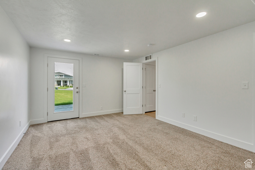 Empty room featuring light colored carpet