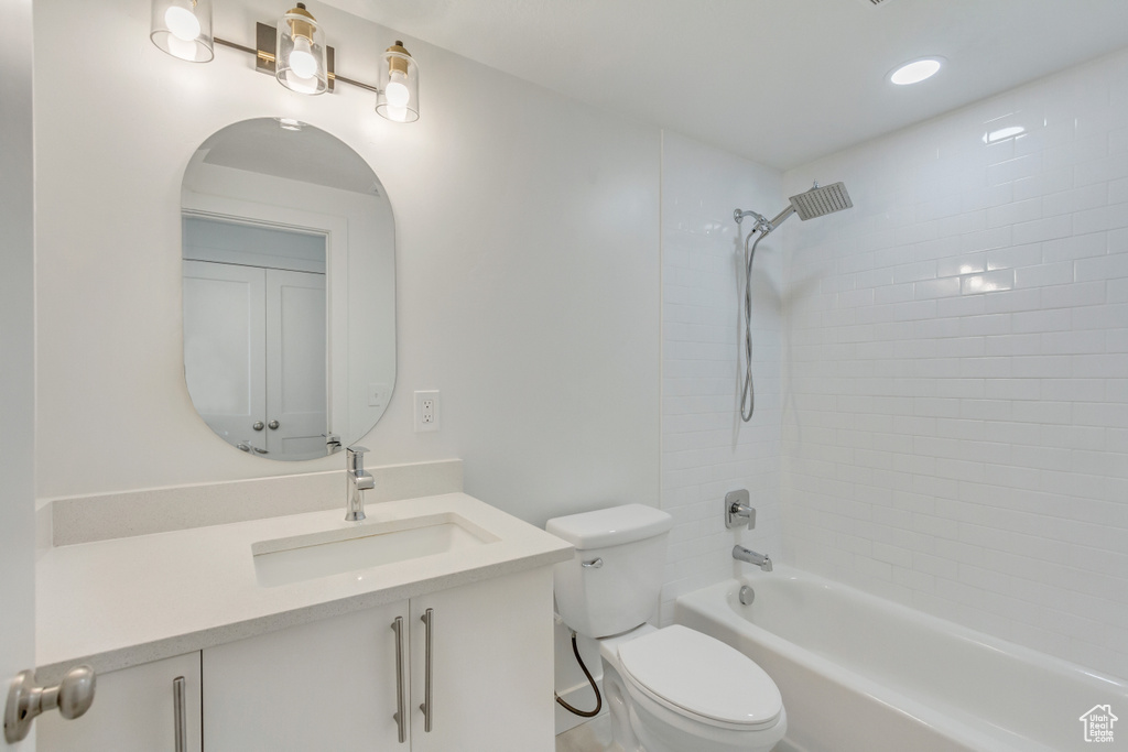 Full bathroom featuring vanity, tiled shower / bath, and toilet