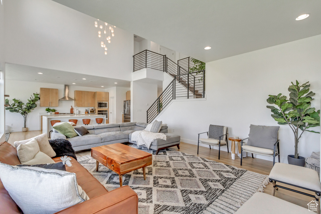 Living room with a high ceiling and light hardwood / wood-style floors