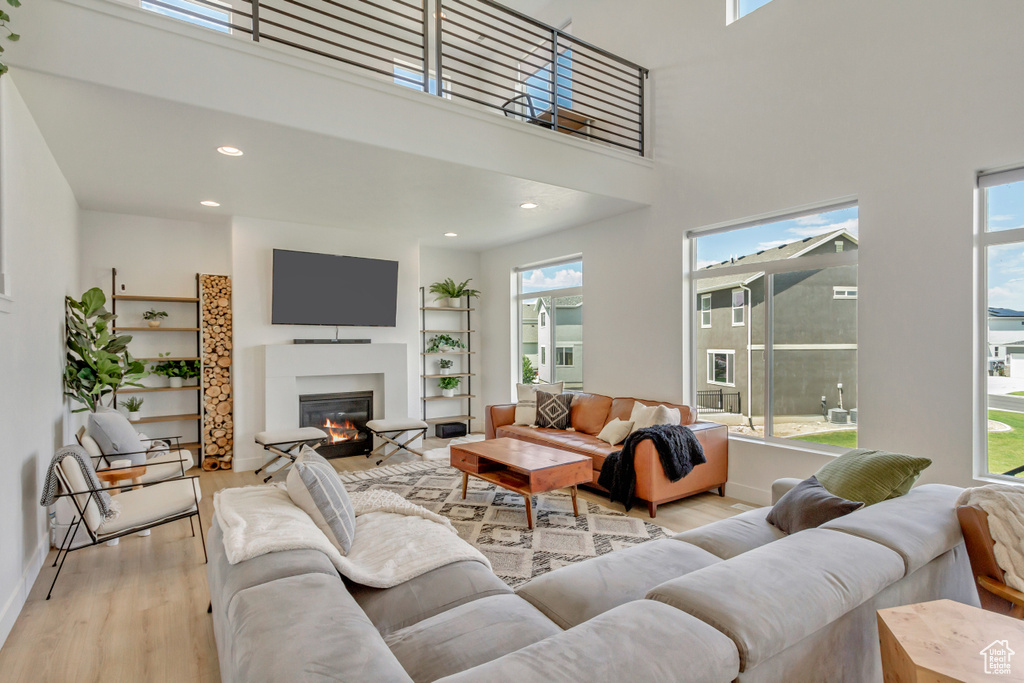 Living room featuring a high ceiling and light hardwood / wood-style floors