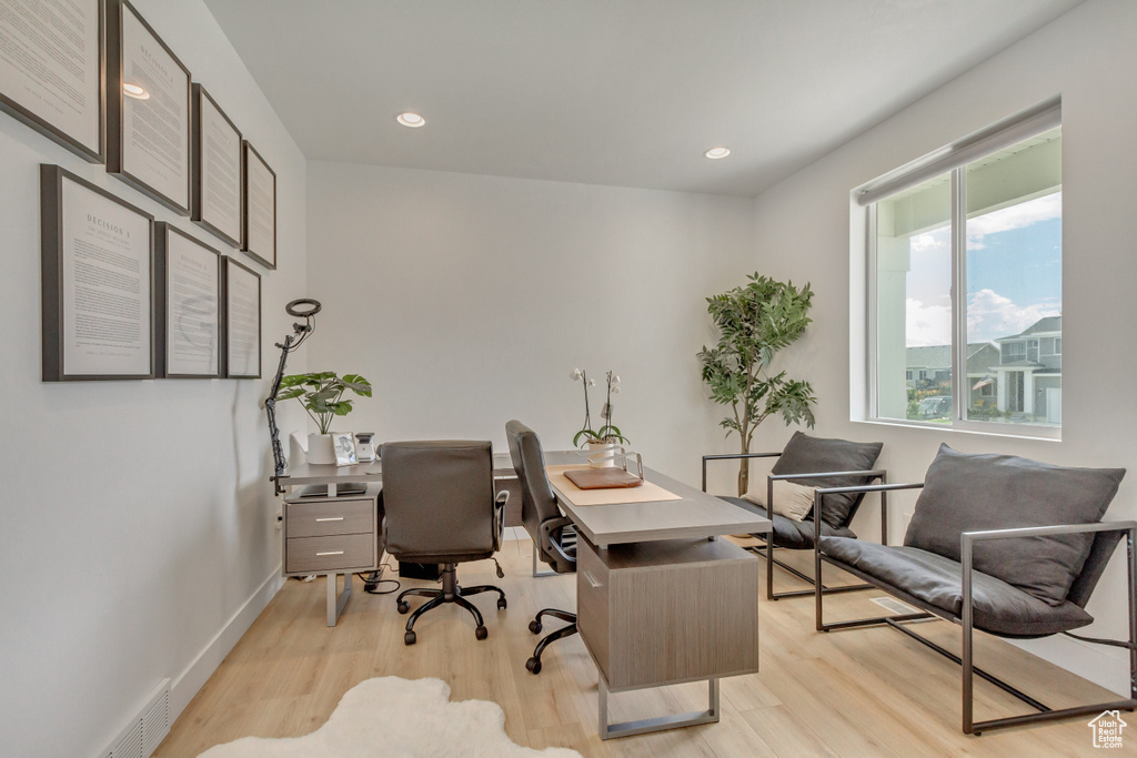 Office space with light hardwood / wood-style floors