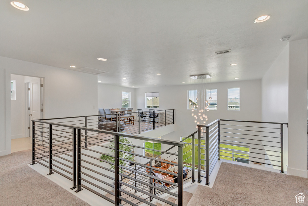 Hallway with plenty of natural light and light carpet