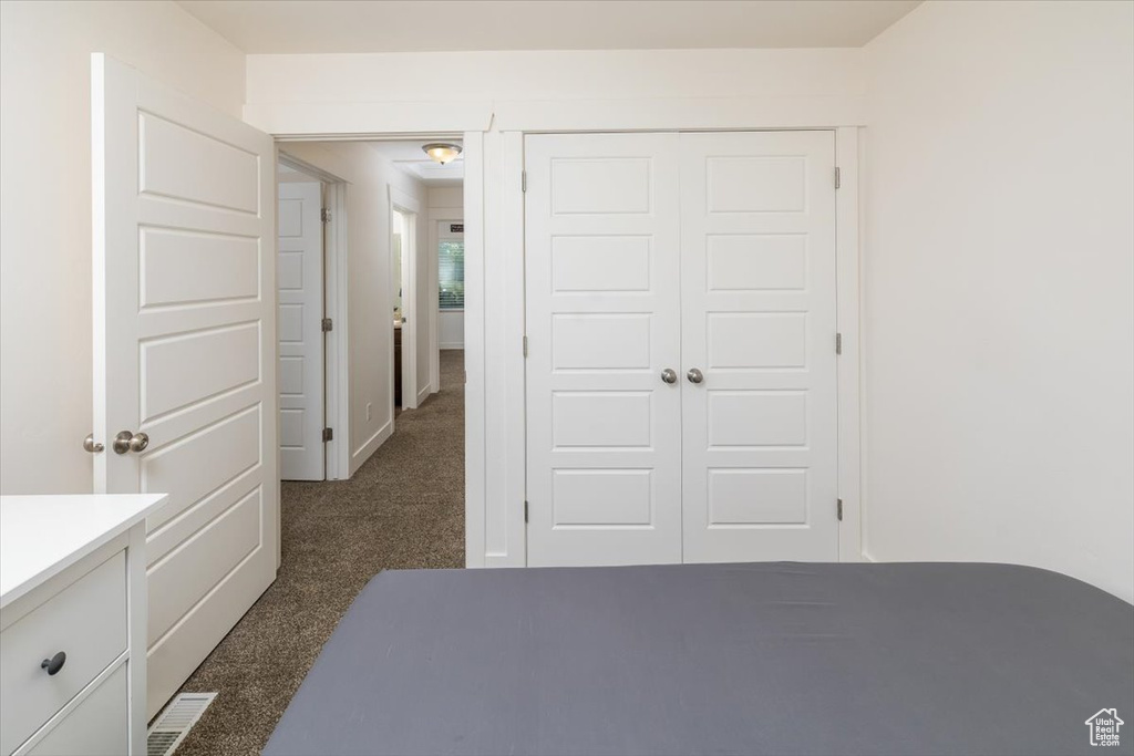 Unfurnished bedroom with a closet and dark colored carpet