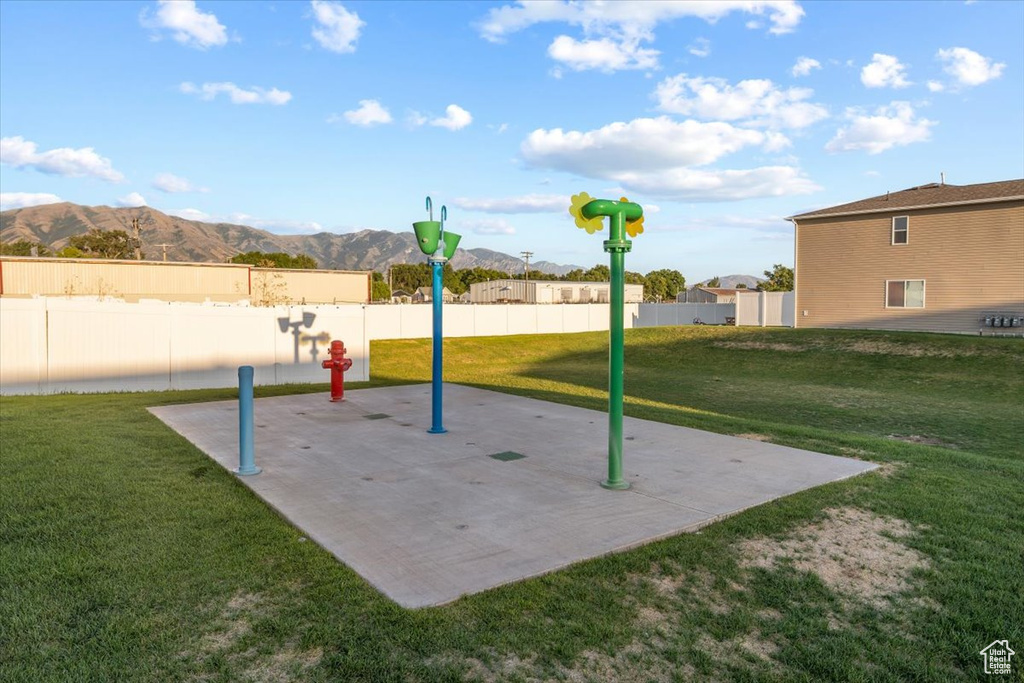 Surrounding community featuring a mountain view, a patio area, and a lawn