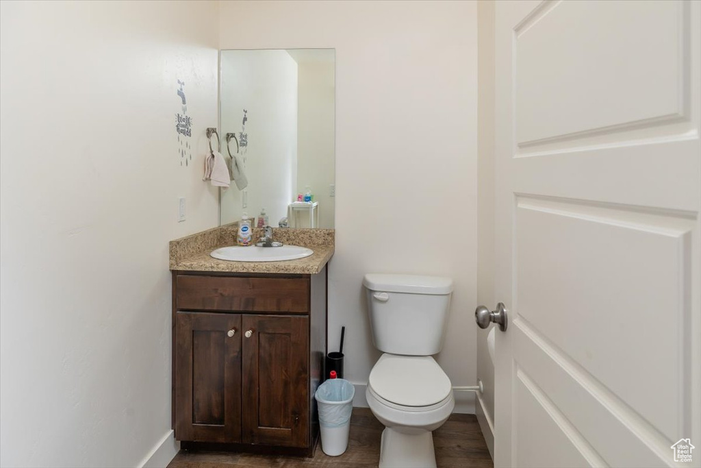 Bathroom featuring vanity, toilet, and hardwood / wood-style flooring