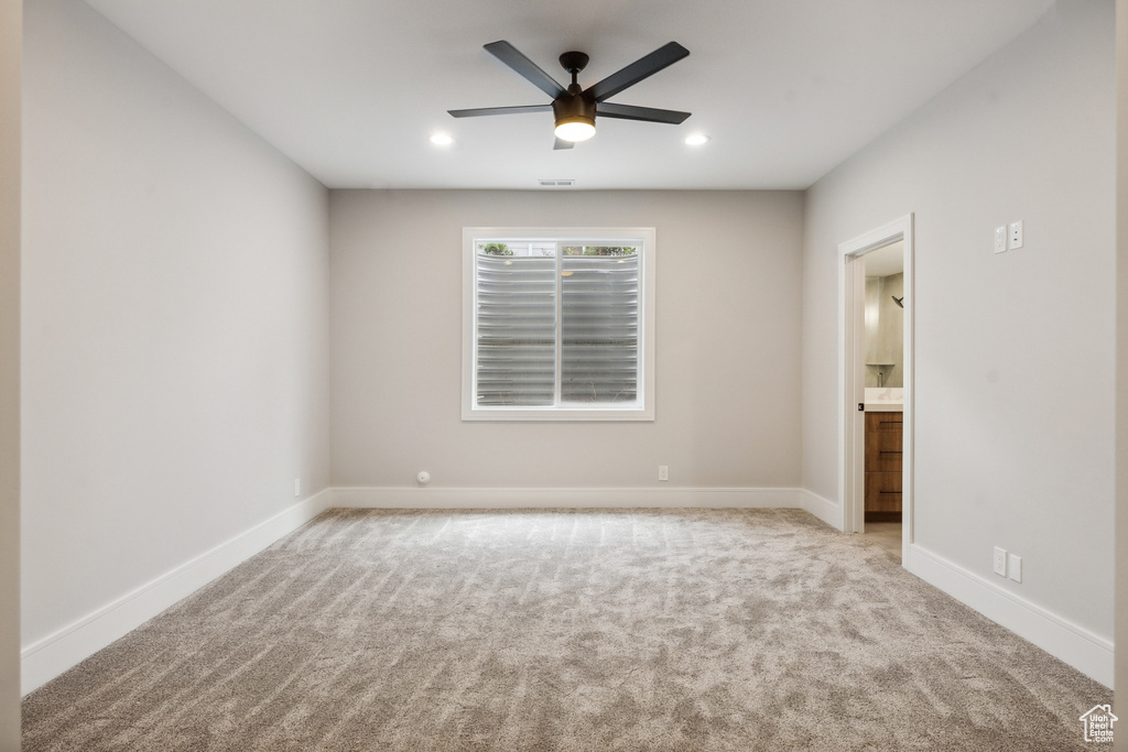 Carpeted empty room featuring ceiling fan