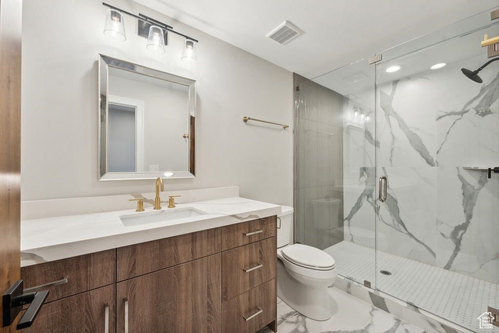 Bathroom with tile patterned floors, vanity, a shower with door, and toilet