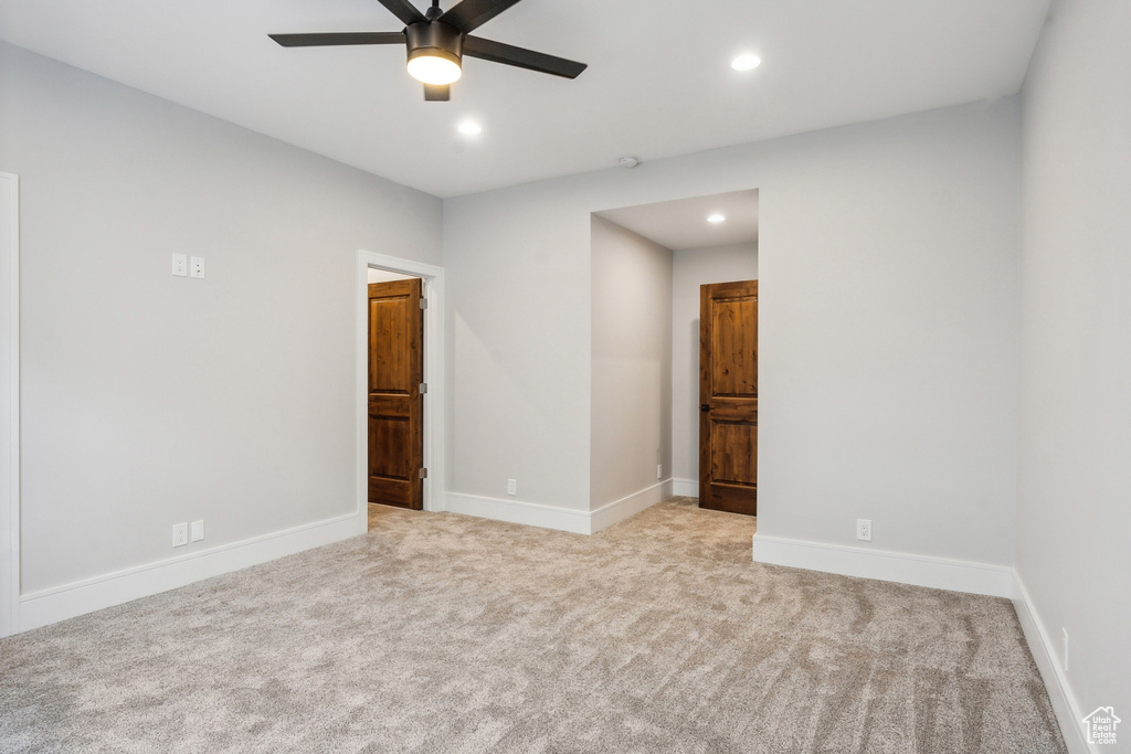 Unfurnished room featuring ceiling fan and light carpet