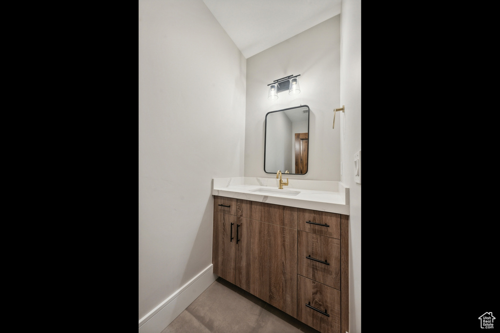 Bathroom featuring lofted ceiling, tile patterned floors, and vanity