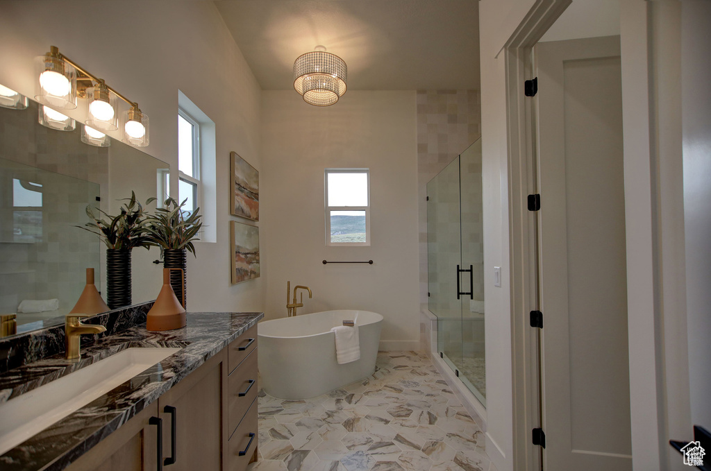 Bathroom featuring a shower with shower door, vanity, and tile patterned flooring