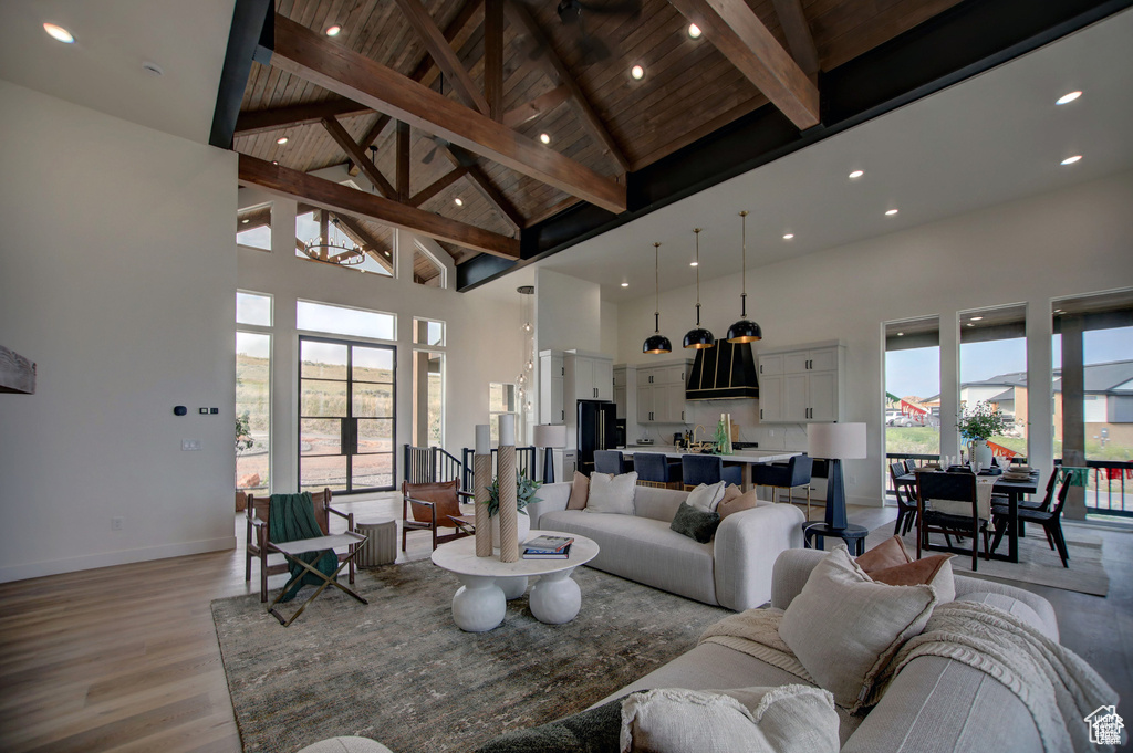 Living room featuring beam ceiling, high vaulted ceiling, light hardwood / wood-style floors, and wood ceiling