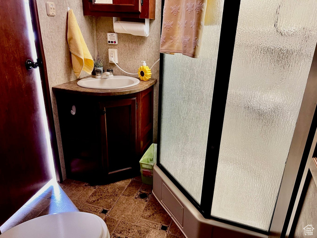 Bathroom with toilet, tile patterned floors, and vanity