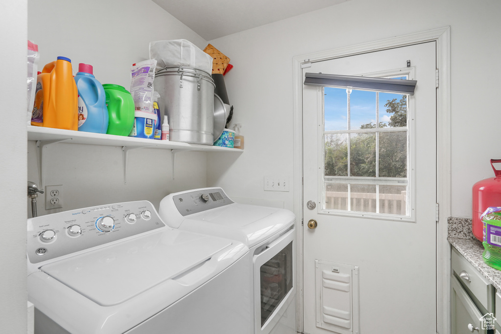 Laundry area featuring separate washer and dryer and cabinets