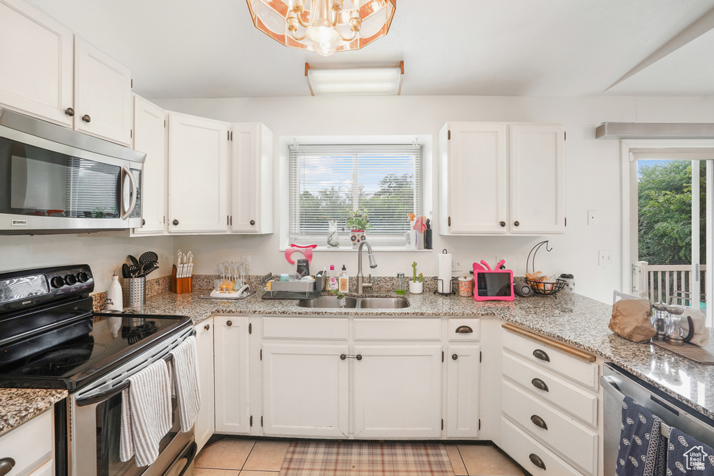 Kitchen with sink, white cabinets, plenty of natural light, and stainless steel appliances