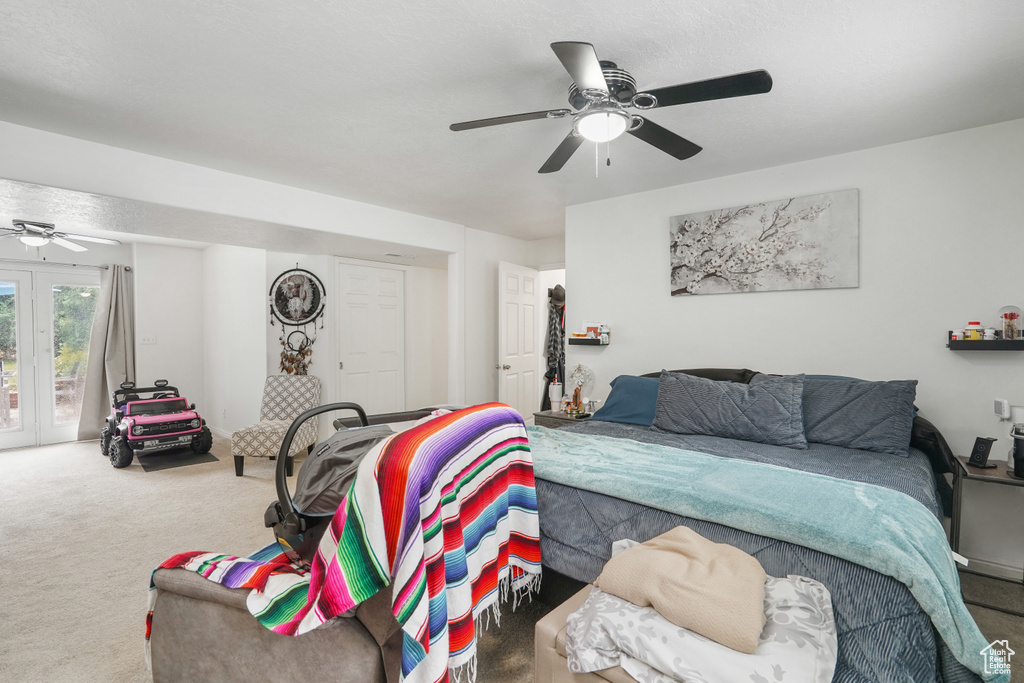 Carpeted bedroom featuring ceiling fan and access to exterior