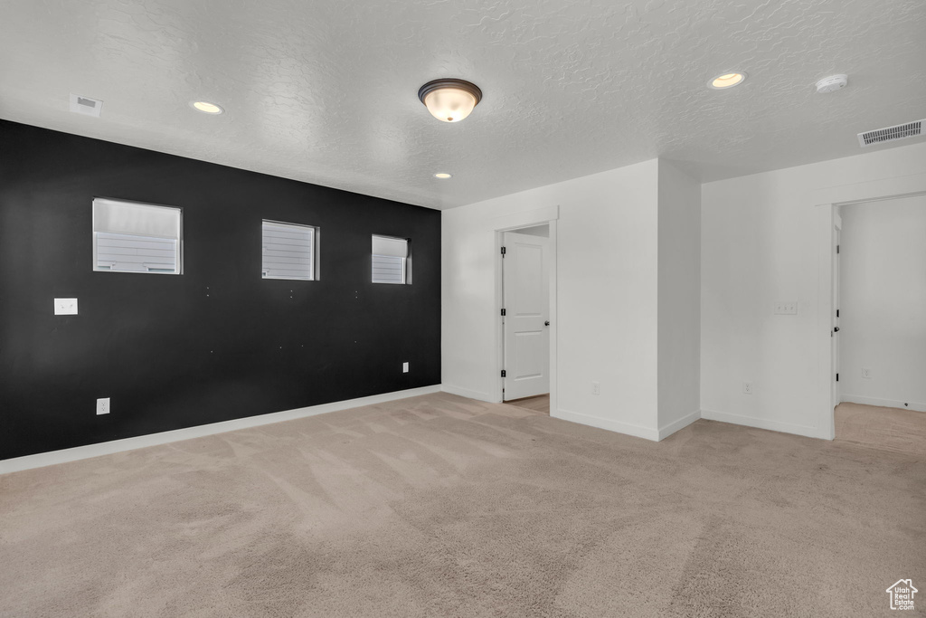 Carpeted empty room with a textured ceiling