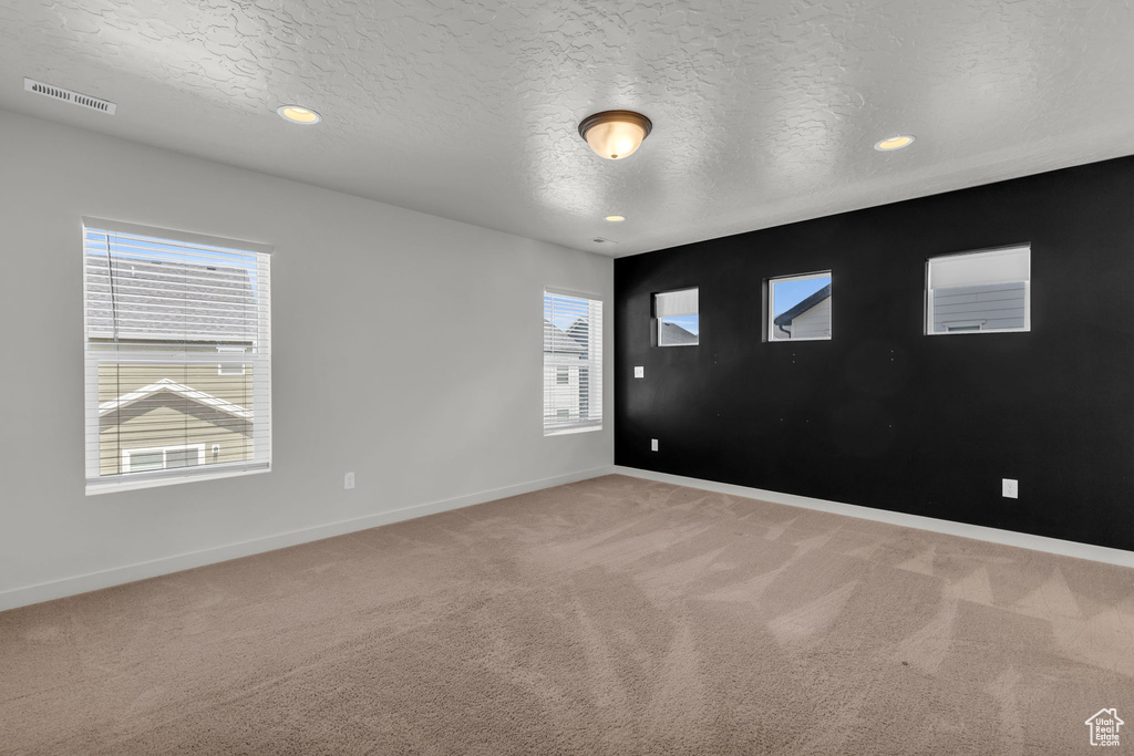 Carpeted empty room with a textured ceiling