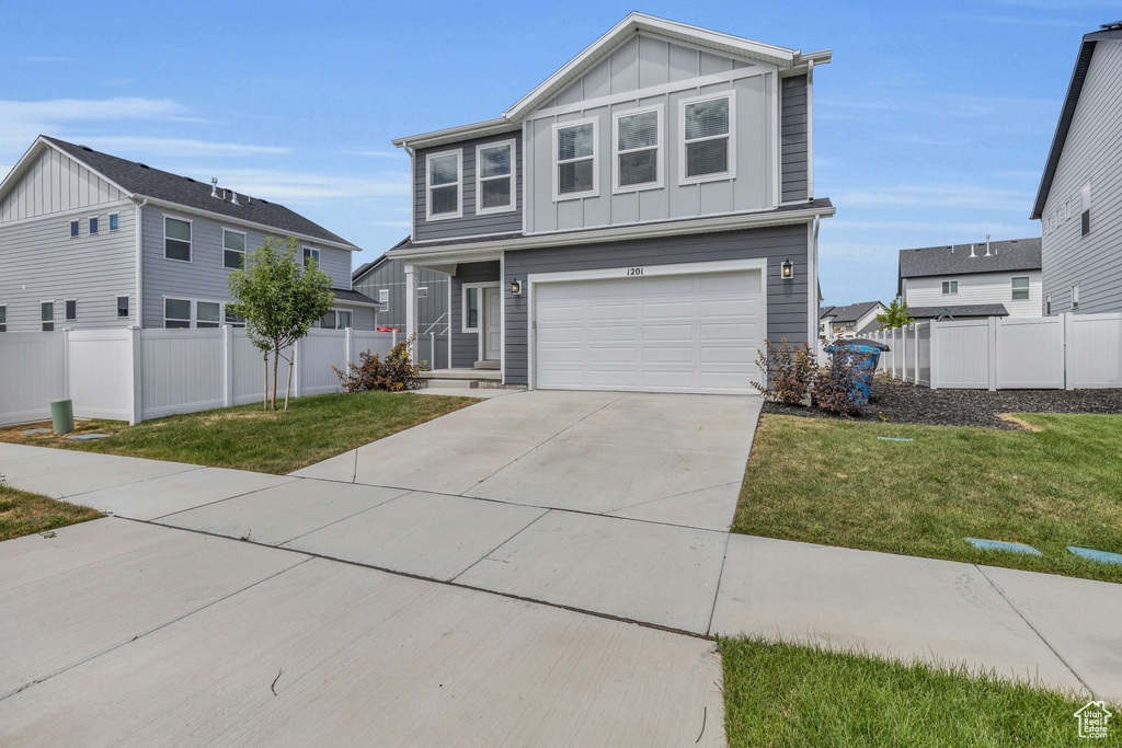 View of front of property with a front lawn and a garage