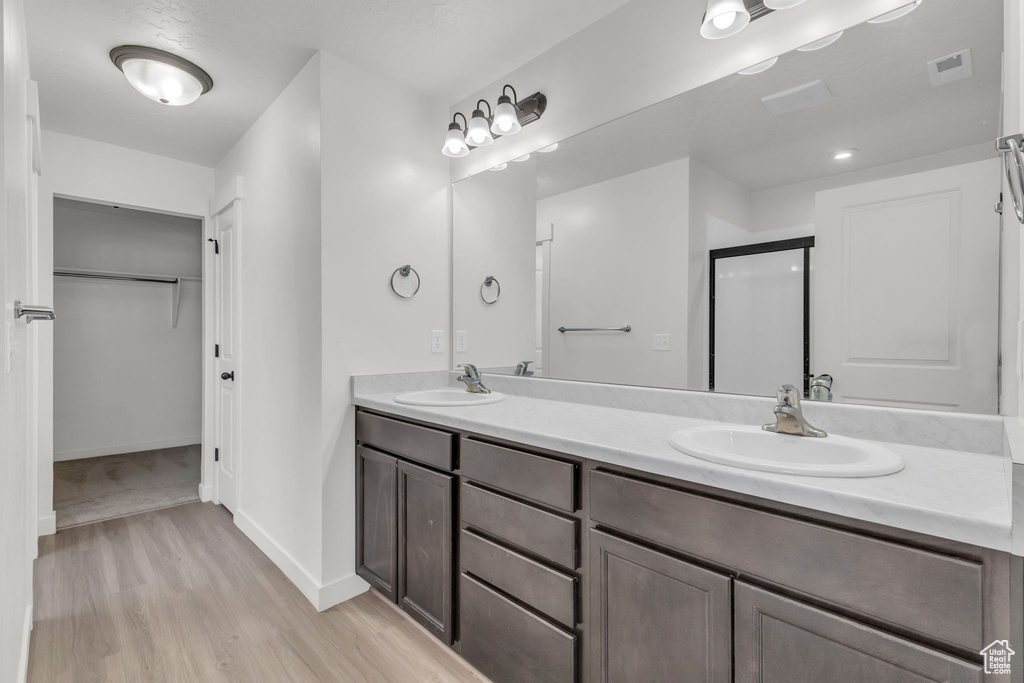 Bathroom featuring dual bowl vanity and hardwood / wood-style floors