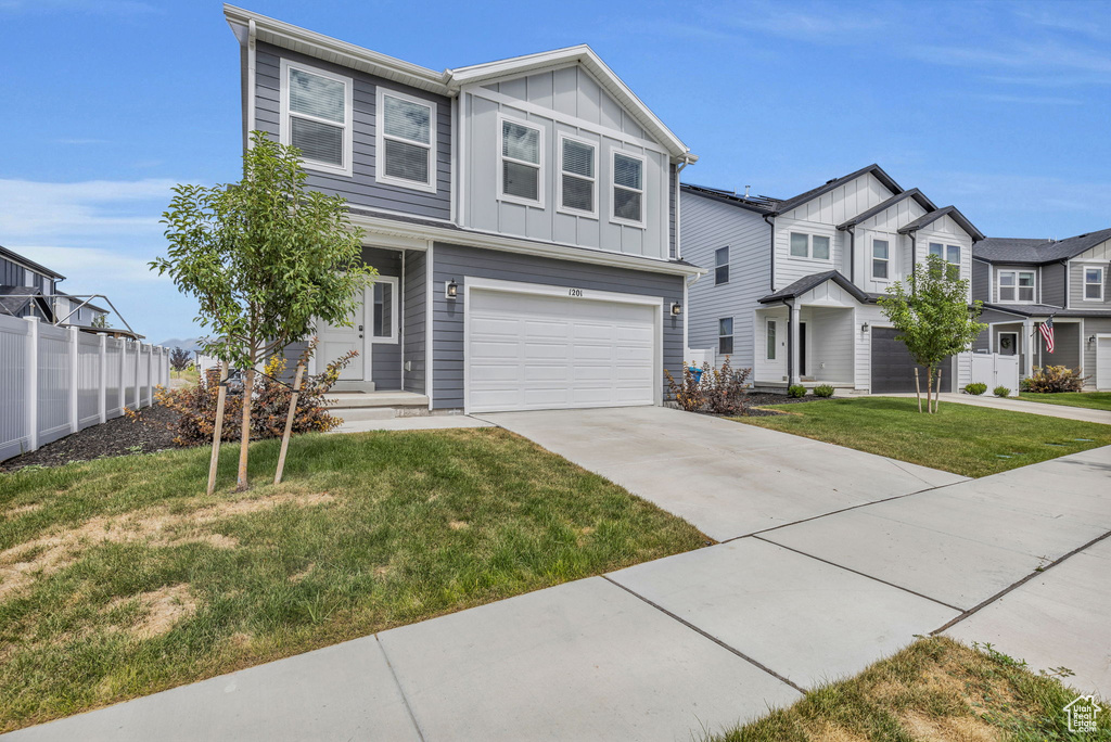 View of front of home with a garage and a front yard