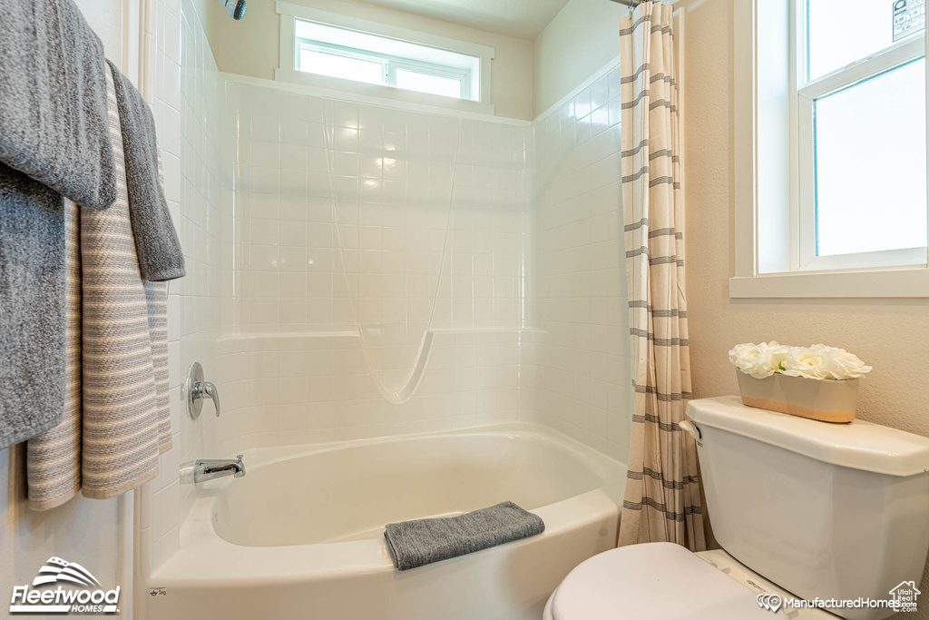 Bathroom featuring shower / bath combo and toilet