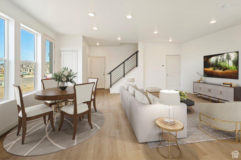 Living room with light hardwood / wood-style flooring and a healthy amount of sunlight