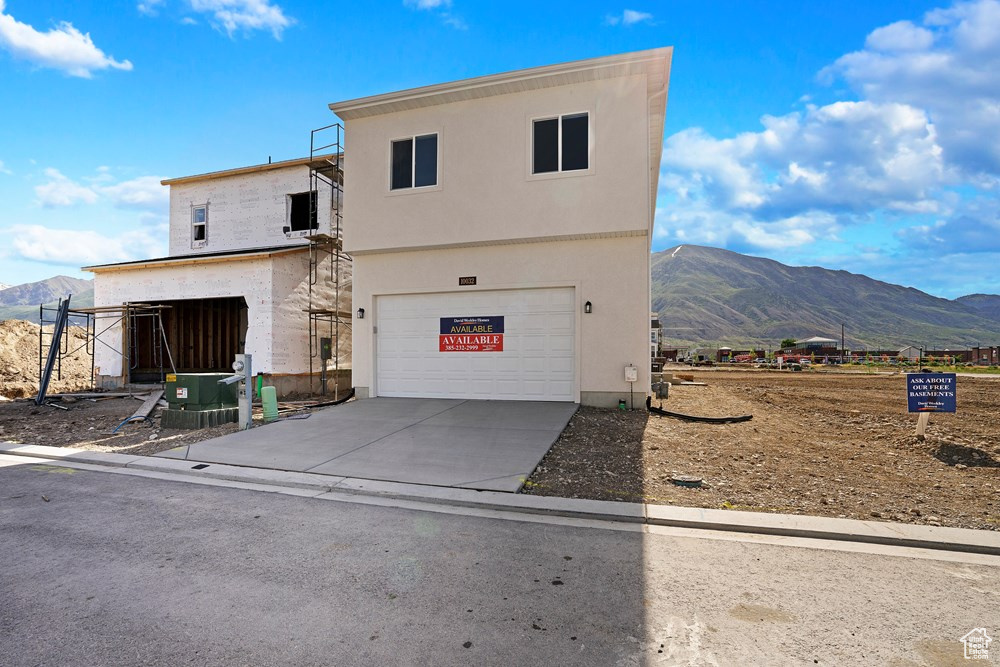 View of front facade with a mountain view and a garage