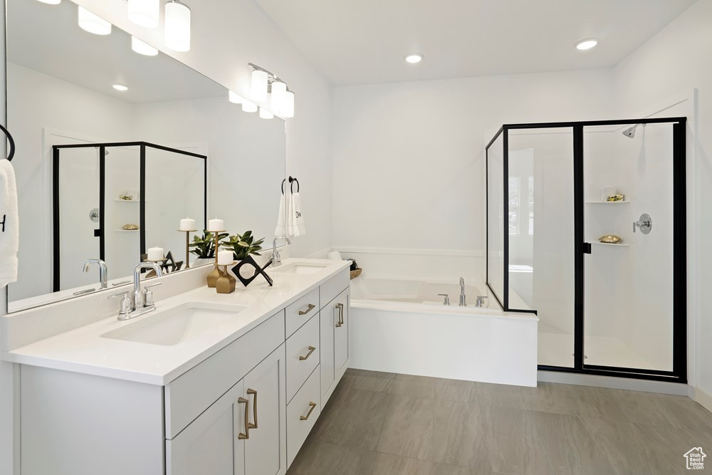 Bathroom with tile patterned floors, double sink vanity, and separate shower and tub