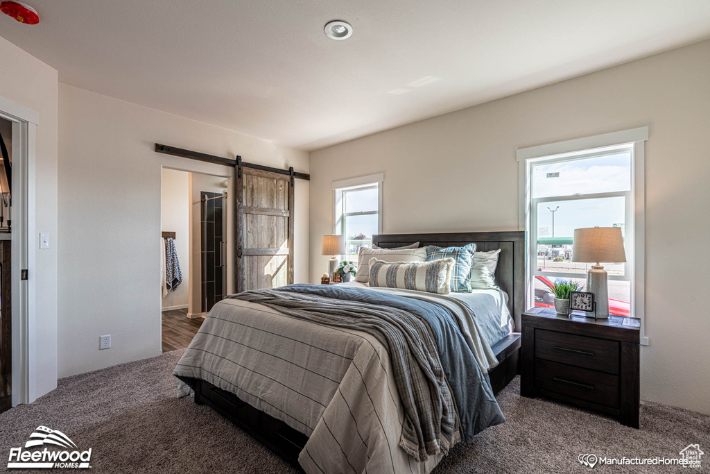 Carpeted bedroom featuring a barn door