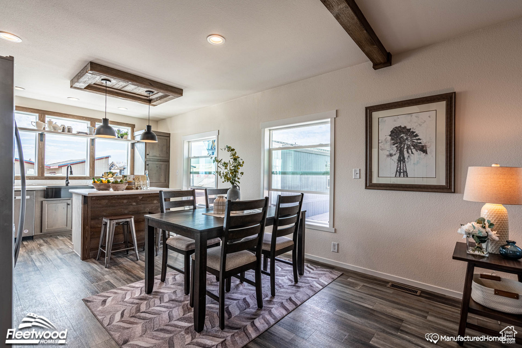 Dining area with sink, beamed ceiling, and dark hardwood / wood-style floors