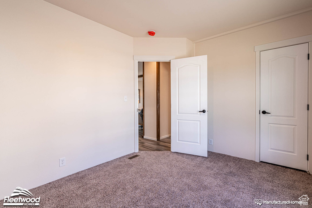 Unfurnished bedroom featuring dark carpet