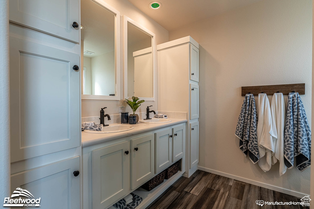 Bathroom with dual vanity and hardwood / wood-style floors