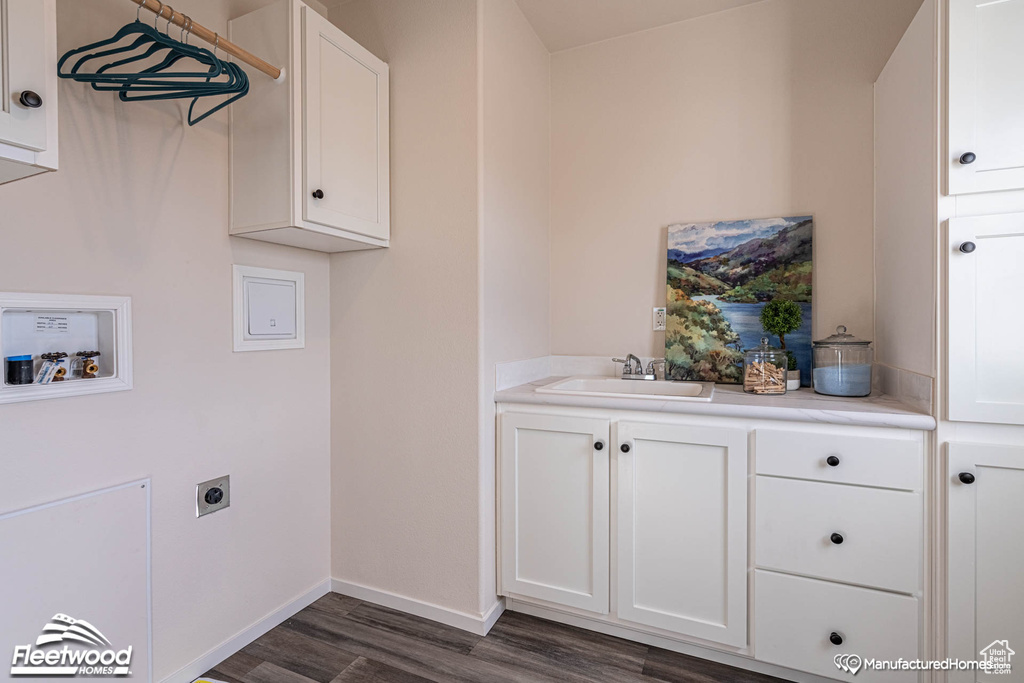 Laundry room with dark hardwood / wood-style flooring, cabinets, electric dryer hookup, sink, and washer hookup