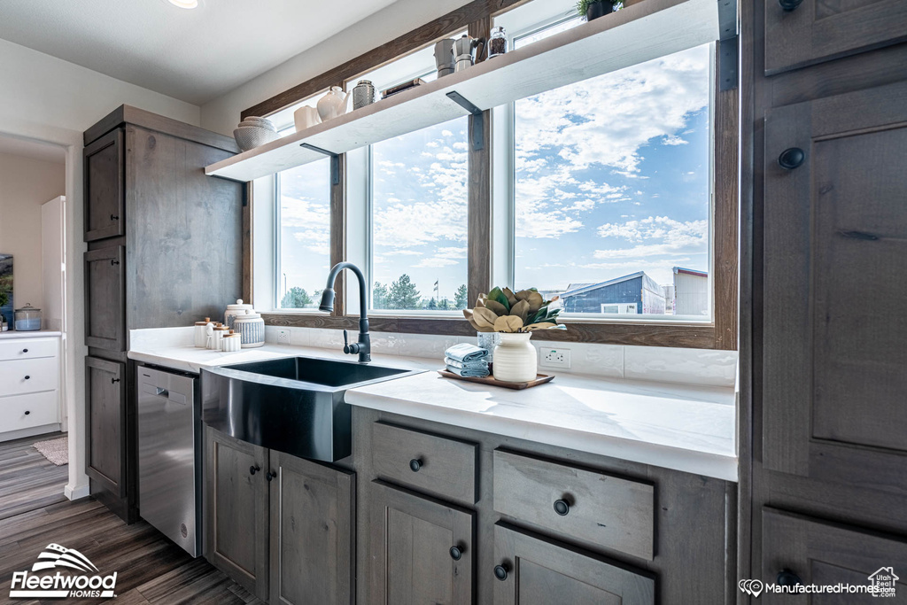 Kitchen featuring sink, dark wood-type flooring, and dishwasher